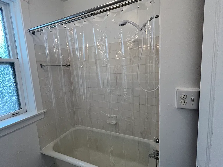 Bathroom has full tub with shower.