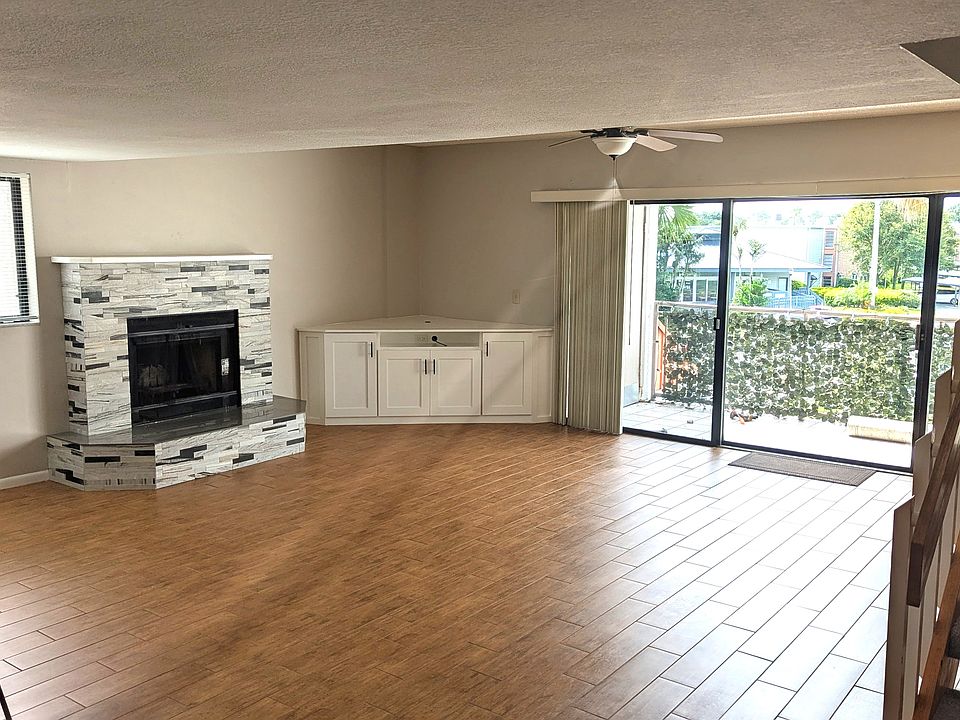 TV/Family Room with Fireplace, ceiling fan, balcony, gorgeous ceramic tile floors