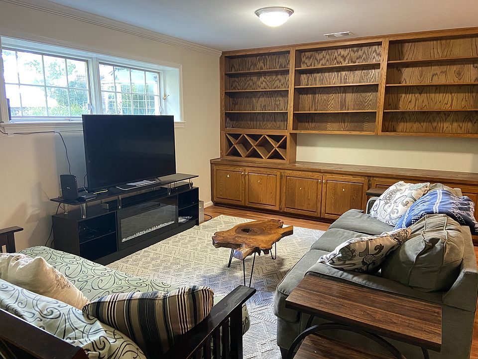 Spacious living room with electric fireplace and full entertainment system, ample cabinet space, built in shelving, wine racks