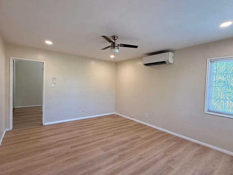 Living room with AC split and recessed lighting. North and east facing windows.