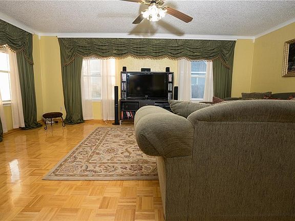 Living room has sizable windows with custom drapes