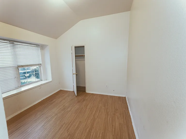 The fourth bedroom with closet features a charming bay window and vaulted ceilings, creating a bright and airy atmosphere