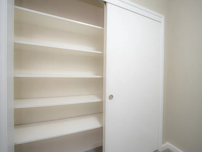 Maximize your space with this conveniently organized closet, featuring elegant sliding doors.