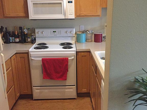 Kitchen overlooks dining area through floating cabinets.