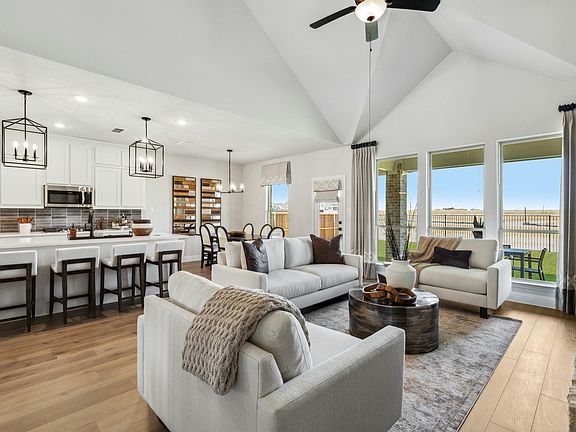 Open concept living room, kitchen, and breakfast nook in a new traditional style model home at Wests