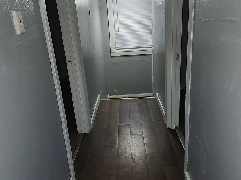 This photo was taken from the bathroom that shows the hallway as you come up the stairs from the living room, leading to the four bedrooms