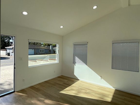 Sun-filled living space with high ceilings, multiple windows, and open layout.