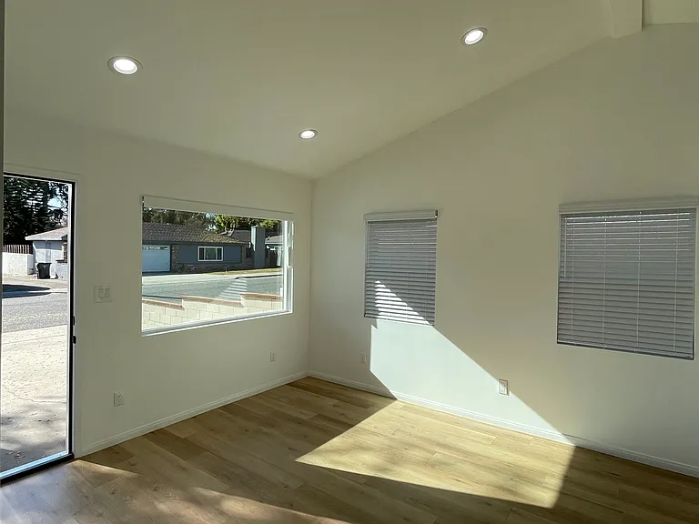 Sun-filled living space with high ceilings, multiple windows, and open layout.
