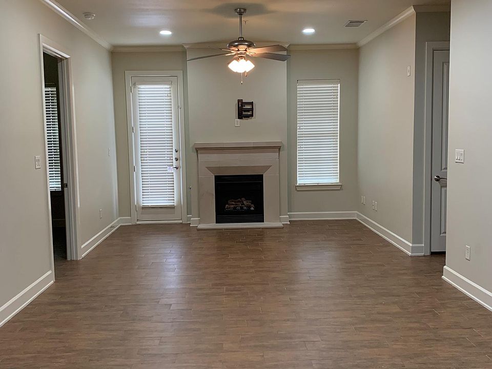 Spacious living room with gas log fireplace and balcony outside