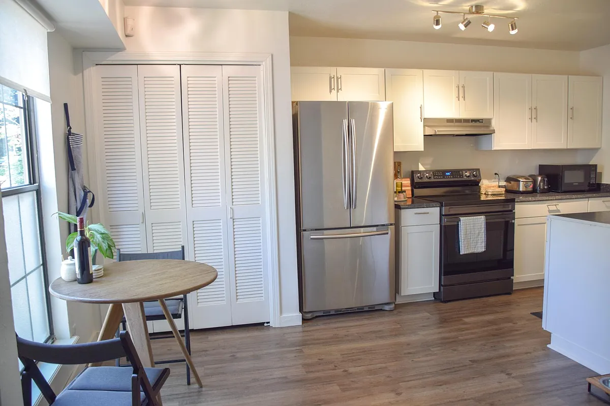Galley-style kitchen with updated appliances and large pantry. - 1424 S Saint Louis Ave #E
