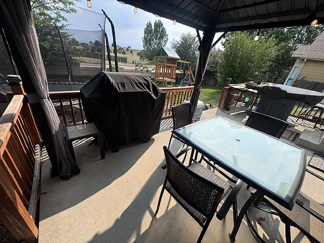 Backyard with a covered gazebo, string lights, grill, fire pit, trampoline, play structure, and mountain views. Across the street from a park, walking trails, and Explorer Elementary.