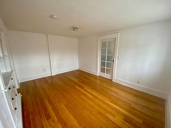 View of the bedroom from the closet corner looking at the door to the living room/kitchen.