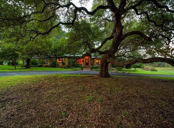 Majestic oak anchors the front driveway area.