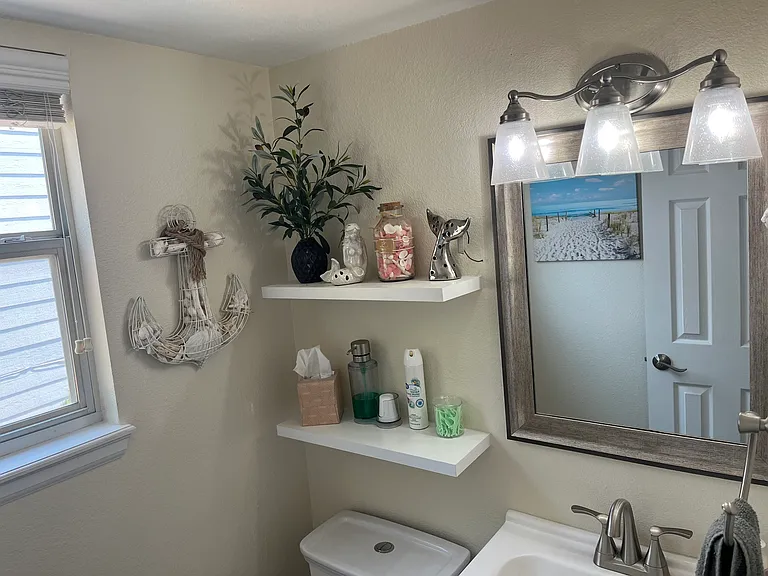 Half bathroom has natural light and cute decor