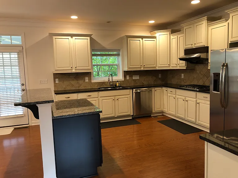 granite counter top in kitchen, vented out range hood over gas cook top