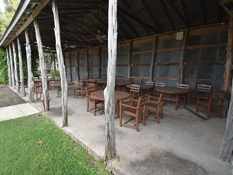 Covered pavilion with tables and chairs overlook the community pool.