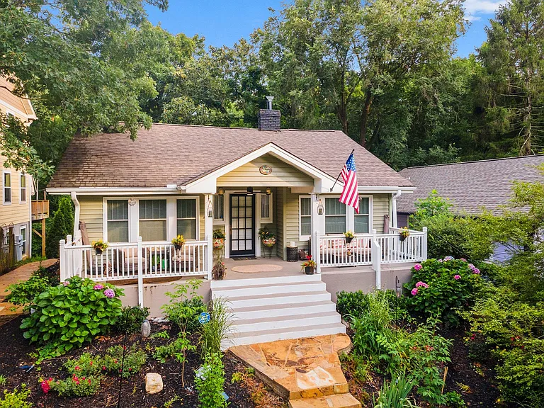 Front porch with seating for 4 with outdoor furniture and sun umbrella's.