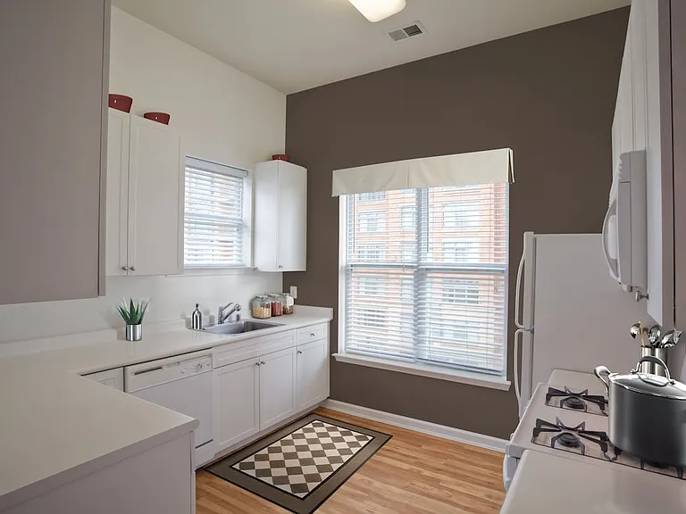 Classic I kitchen with white appliances, white cabinetry, and hard surface flooring