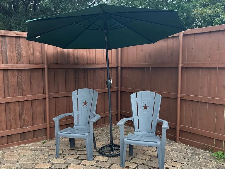 Outdoor patio with chairs and umbrella.