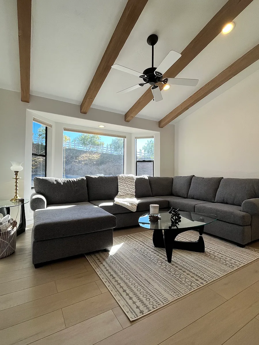 To the left of the front door is a spacious, sunken living space with natural wood beams - 40491 Green Oaks Dr