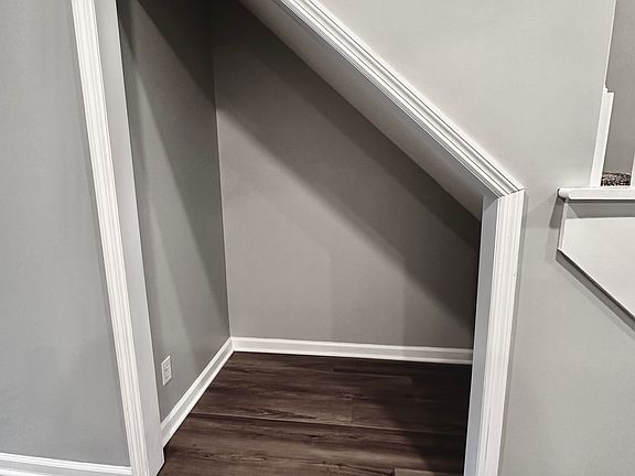 Newly remodeled nook under stairs in 2025. New floors, paint, carpet, electrical, fan, and serviced fireplace.