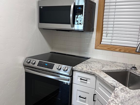 Granite Countertops, Stainless steel sink, Stainless steal microwave and stove, full size refrigerator. Shaker cabinets.