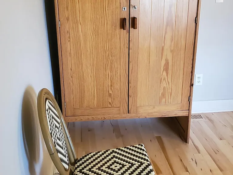 This bedroom has a solid wood wardrobe.