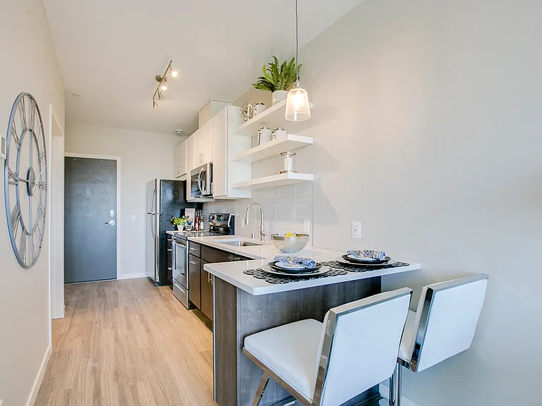 The kitchen in this studio layout offers a breakfast bar with seating space.