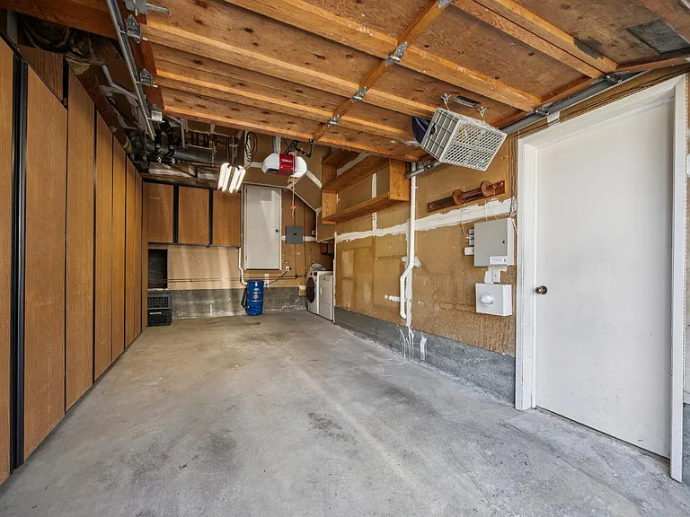 Private garage with a wall of cabients on the left and laundry on the right.