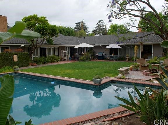 Absolutely Stunning Backyard features sparkling pool, cozy fire pit, and many separate seating areas... perfect for entertaining or relaxing in style!