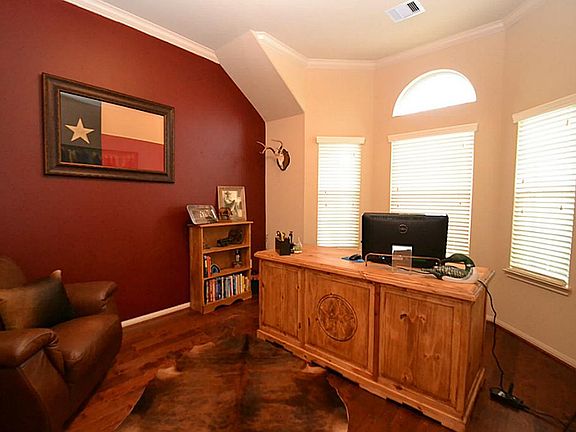 French doors open to the study accented by hand scraped hardwood floors, raised ceilings and crown m