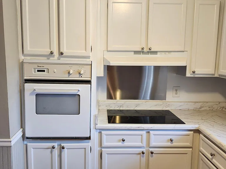 Kitchen: Closeup view revealing oven, new stovetop and freshly painted cabinets
