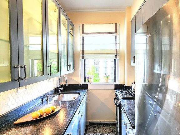 Galley kitchen w/ stainless appliances; new full-size refrigerator, dishwasher, and disposal.