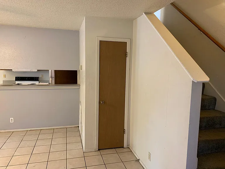 Open spacious Living with coat closet and stairs leading to upper bedrooms.