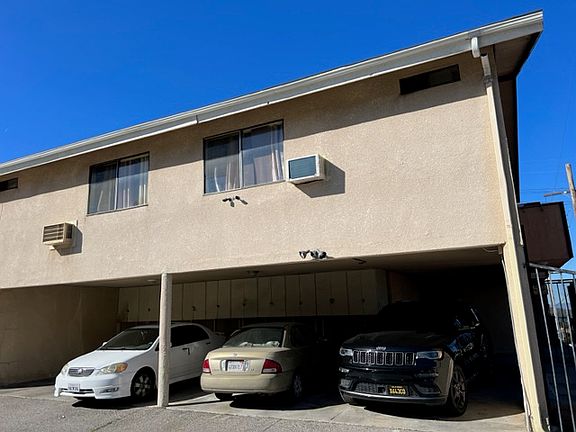 Parking in rear of apartment building with gated access.