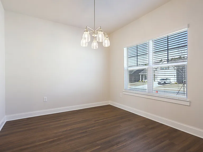 Bright room with wood floors and a large window, perfect for a kitchen table.
