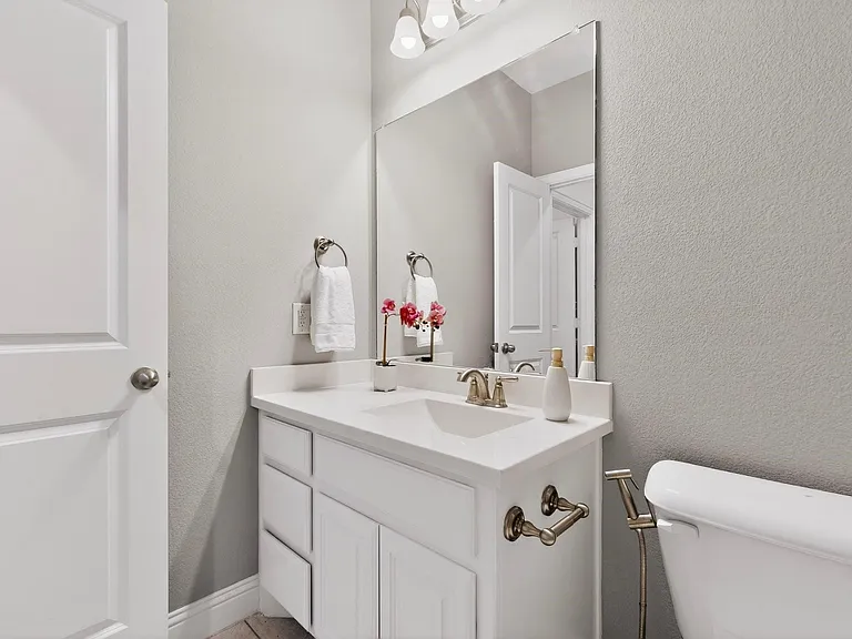 A clean bathroom featuring a toilet with bidet and vanity