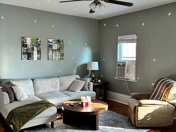 Large living room, natural light beautiful original hardwood floor true to historical character of the home.