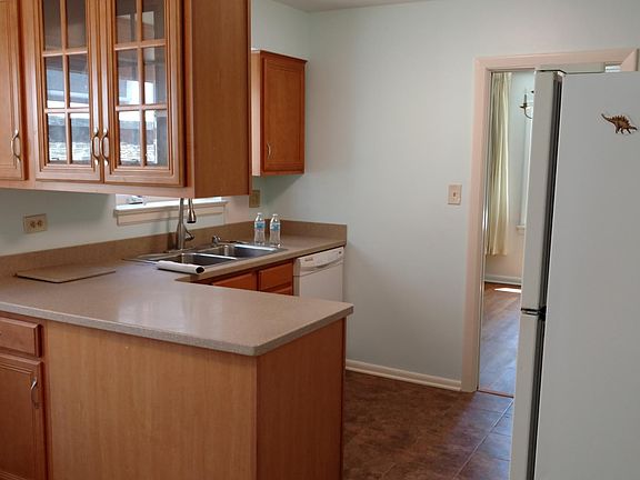 looking southeast from the doorway between the kitchen in the hall. The dishwasher is to the right of the double sink.