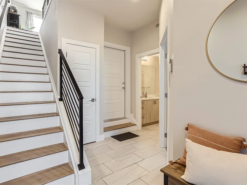 Foyer front entrance with view of 1st floor bedroom, bathroom, coat closet and garage entrance
