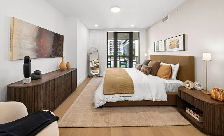 Primary bedroom with balcony view, elegantly furnished with Restoration Hardware pieces.
