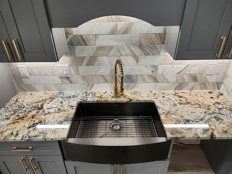 This is a great photo of the massive, gunmetal stainless steel, undermount farmhouse sink, beautiful marble and granite, and under-cabinet lighting you'll get to enjoy for years!