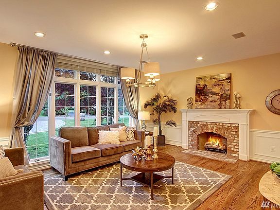 Stepping into the formal living room you'll be warmed by the new used brick surround gas fireplace, hardwood floors, new chrome drum chandelier, white painted wainscoting, wood blinds and silk draperies. 