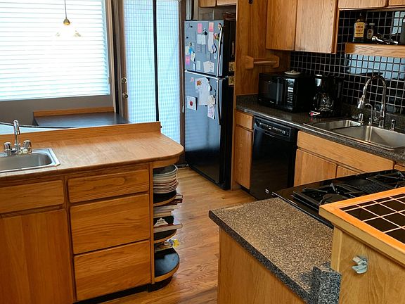 view of updated kitchen with newer downdraft range, newer dishwasher, disposer and prep sink. Kitchen also boasts breakfast nook and French door leading to elevated back deck