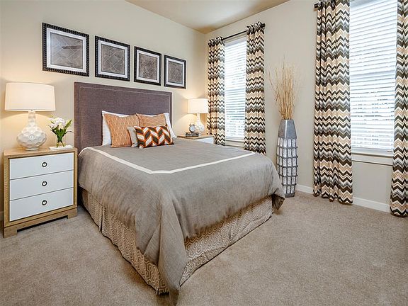 Bedroom with two windows and plush carpeting