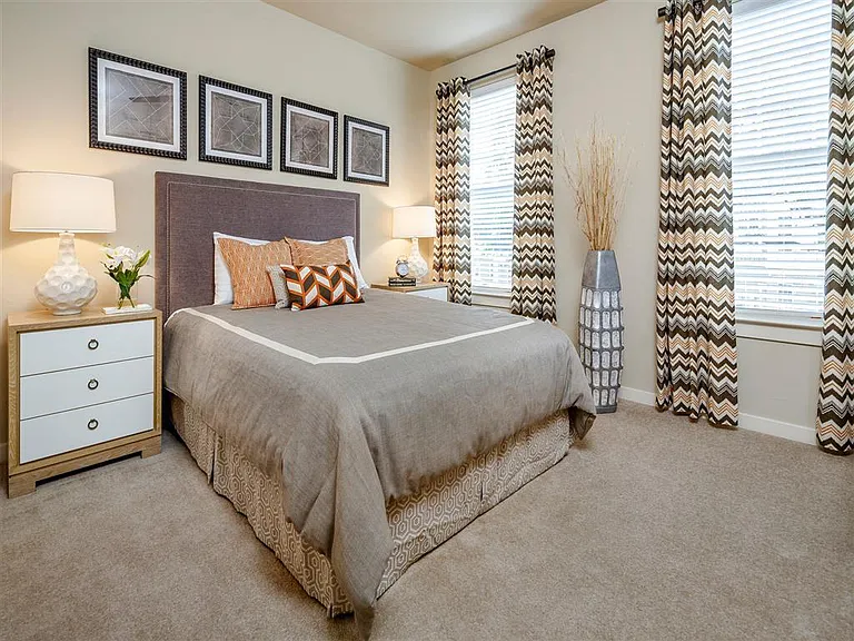 Bedroom with two windows and plush carpeting