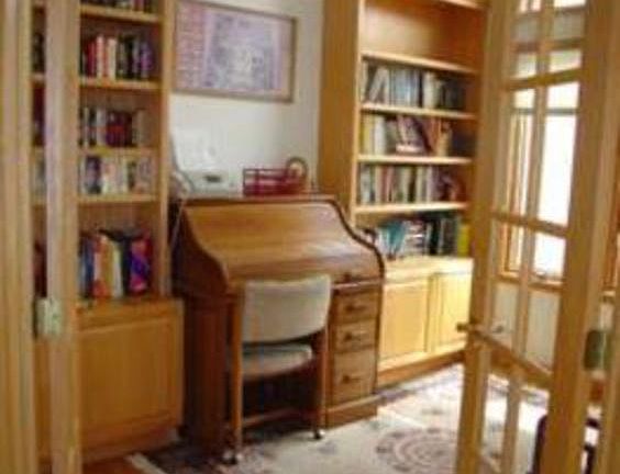 Just to the right of the foyer is the beautiful den, boasting hardwood floors and built-in shelving.