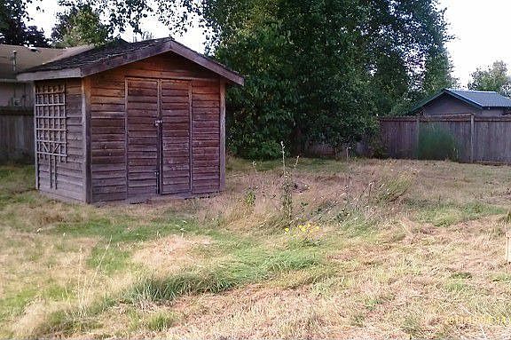 Fenced-in back yard with outbuilding.