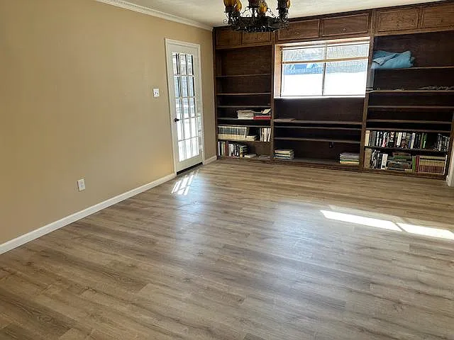 Master suite features built-in hardwood bookcase, Spanish light fixture, door access to patio and access to master bath and separate vanities and walk-in closets.