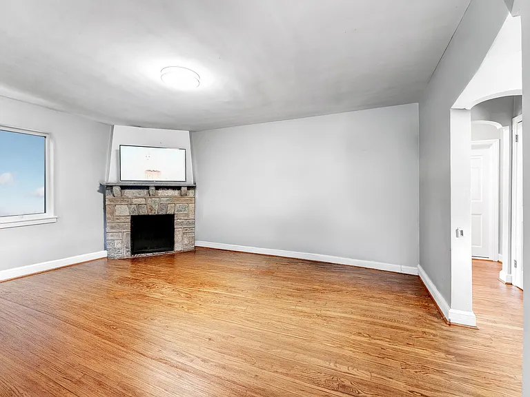 Living room with hardwood flooring sports lots of room for sectional sofa & additional seating